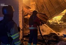 Rescue workers are putting out a fire in a warehouse in the Kyiv region following a Russian attack