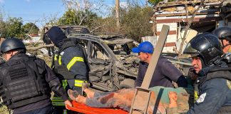 Rescue workers are evacuating a casualty following the Russian strike on Chuhuiv