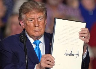 Дональд Трамп демонструє підписаний документ