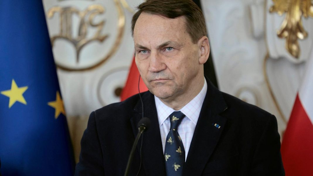 Radosław Sikorski is speaking at the microphone