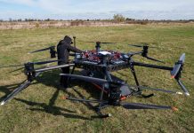 An employee is setting up a large, multi-rotor StarGate drone