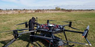 An employee is setting up a large, multi-rotor StarGate drone