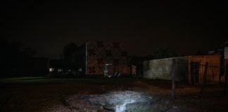 A large crater in the ground following the Russian shelling of Kyiv last night; emergency services are at the scene.