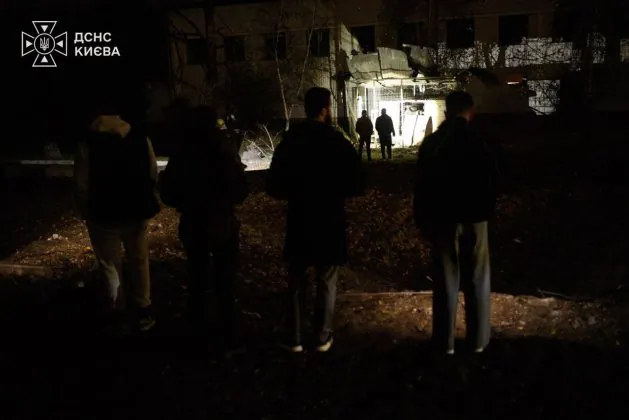 Люди біля пошкодженої будівлі в Києві після нічної балістичної атаки Росії 27 жовтня 2026 року