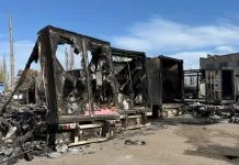 Згорілі вантажівки з обвугленими кузовами та зруйнованими причепами на стоянці в окупованому Донецьку після нічної атаки безпілотників.