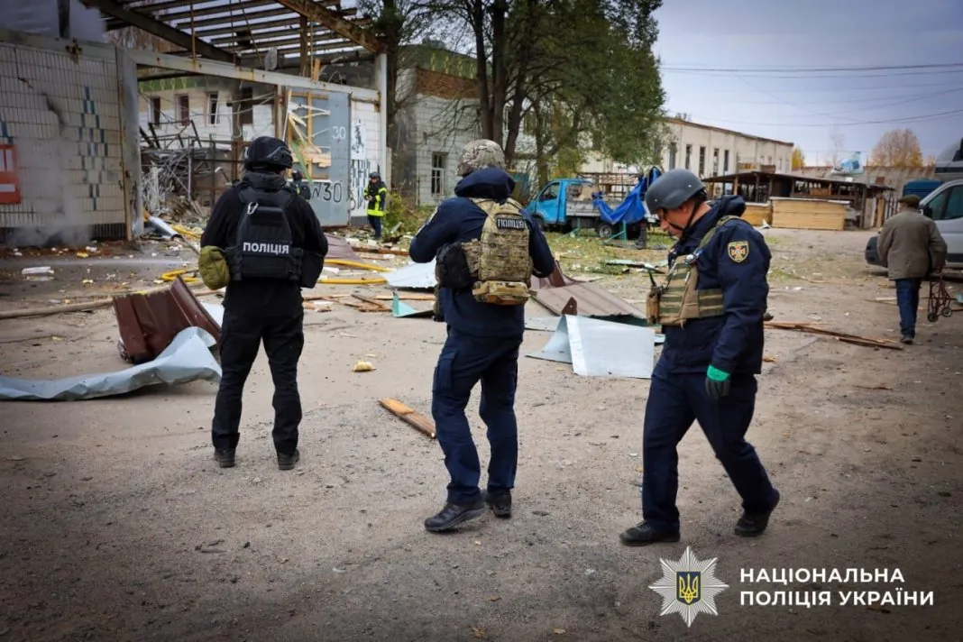 Поліцейські та рятувальник оглядають пошкоджені будівлі й уламки конструкцій після російських обстрілів Сумської області 28 жовтня 2026 року