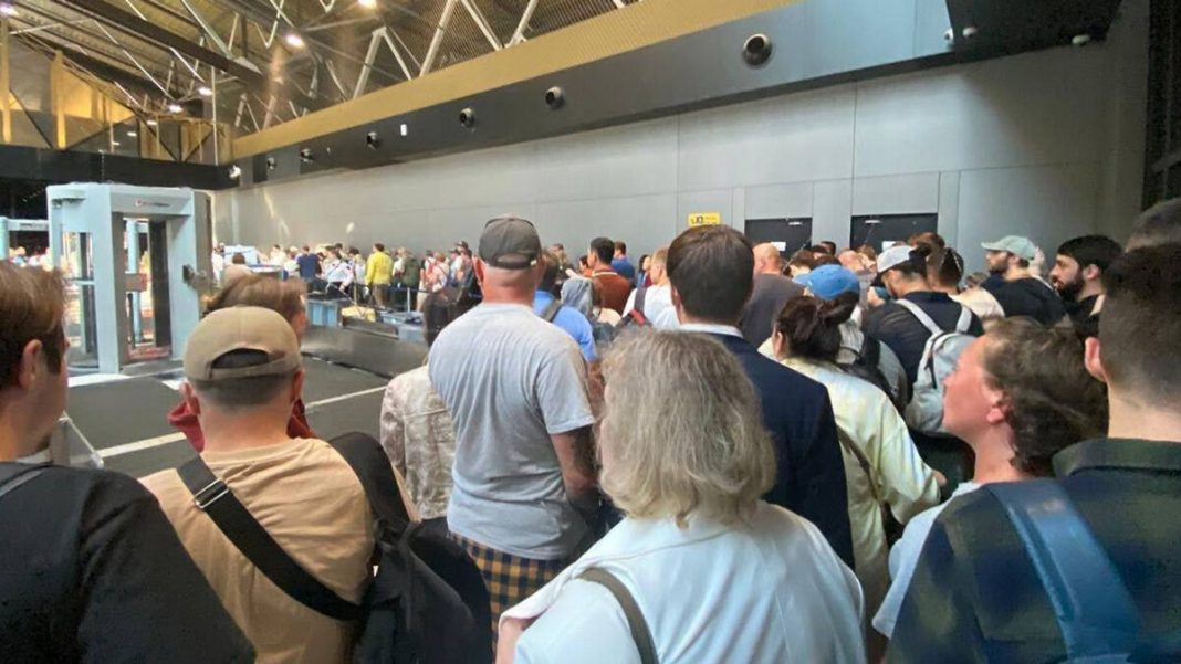 A queue of passengers A queue of passengers at the security checkpoint in the airport terminal