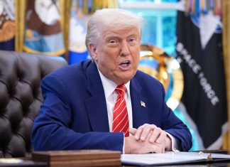 US President Donald Trump at his desk in the Oval Office of the White House