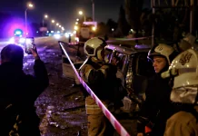 Росія двічі за ніч атакувала Київ балістикою: є загиблий та поранені Рятувальники ДСНС працюють біля пошкодженого автомобіля на місці російської атаки вночі
