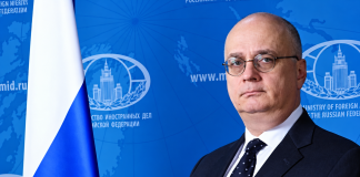 Гутерріш призначив росіянина відповідальним за розмінування в ООН Російський дипломат Гліб Десятников у діловому костюмі на тлі символіки Міністерства закордонних справ Росії та державного прапора РФ