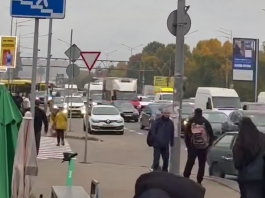 Щільний потік автомобілів та пішоходи на міській дорозі Києва