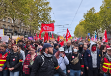 A mass demonstration in France, with red flags of trade unions and political organisations lining the city streets.