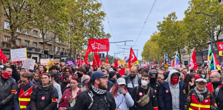 A mass demonstration in France, with red flags of trade unions and political organisations lining the city streets.