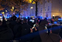 Нічне скупчення людей біля автомобілів із синіми проблисковими маячками