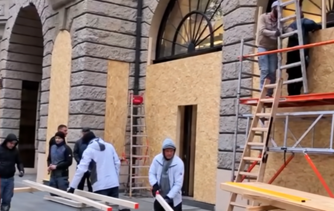 Protests in Germany Workers are fitting wooden panels to the windows and shop fronts of a shop in Germany.